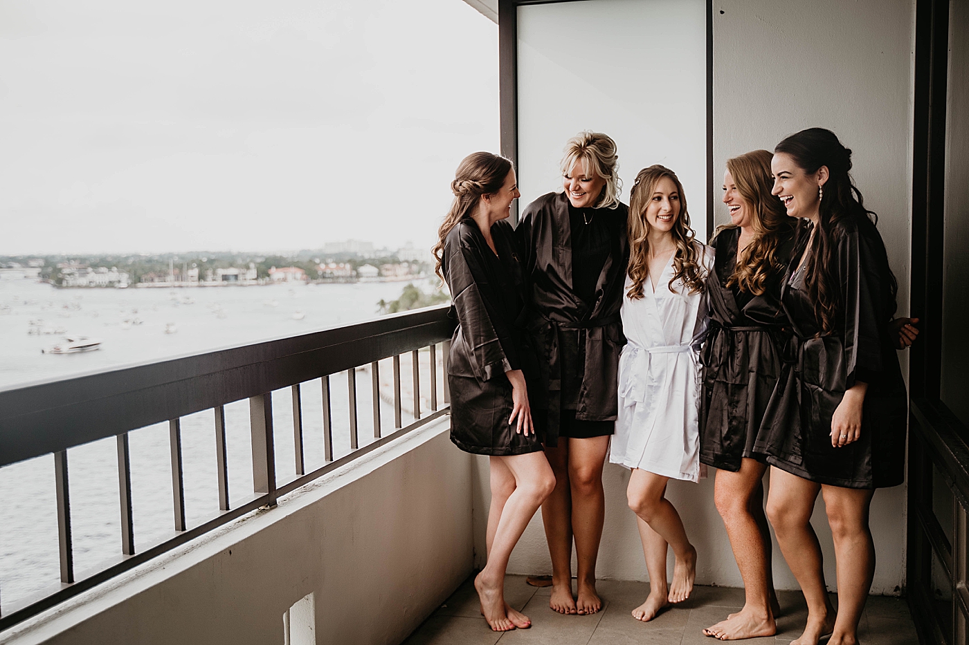 Bride getting ready with bridesmaids by the seaside Waterstone Resort and Marina Wedding captured by South Florida Wedding Photographer Krystal Capone Photography