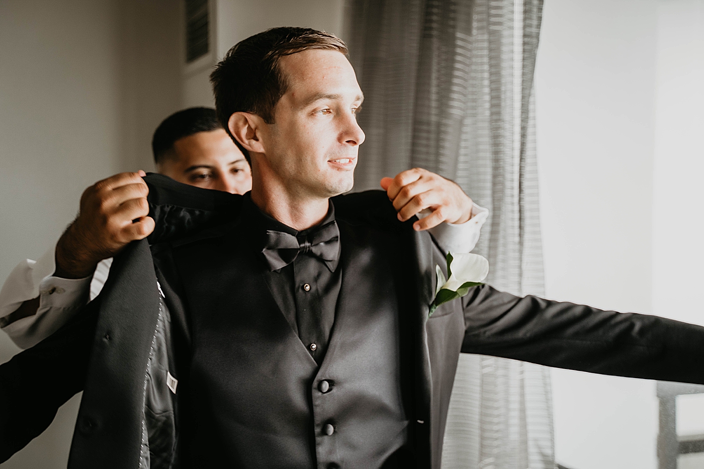Groom getting ready putting jacket on Waterstone Resort and Marina Wedding captured by South Florida Wedding Photographer Krystal Capone Photography