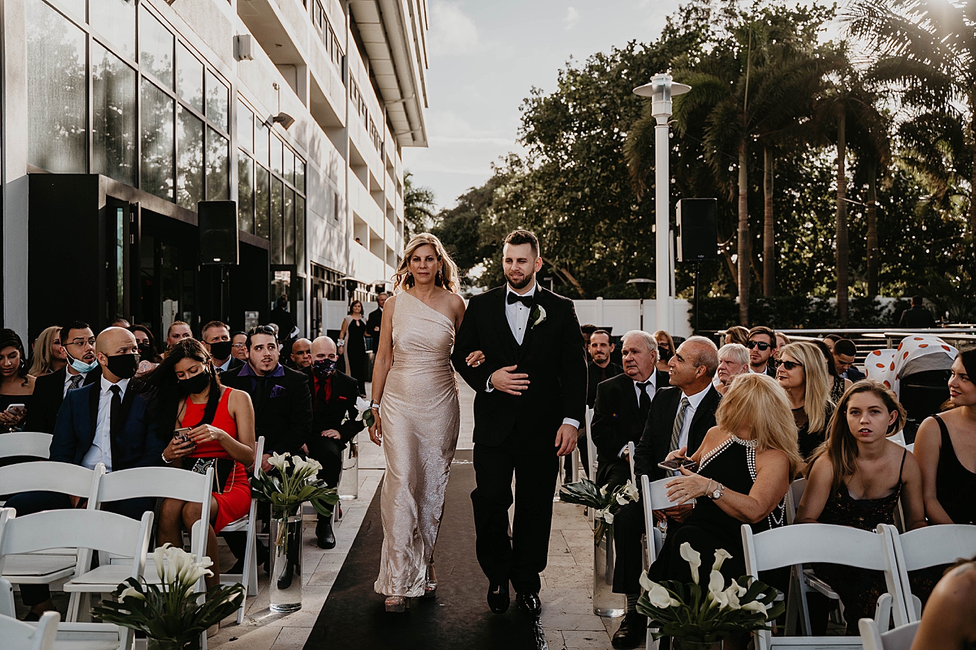Ceremony Family and Bridal party going down the aisle Waterstone Resort and Marina Wedding captured by South Florida Wedding Photographer Krystal Capone Photography