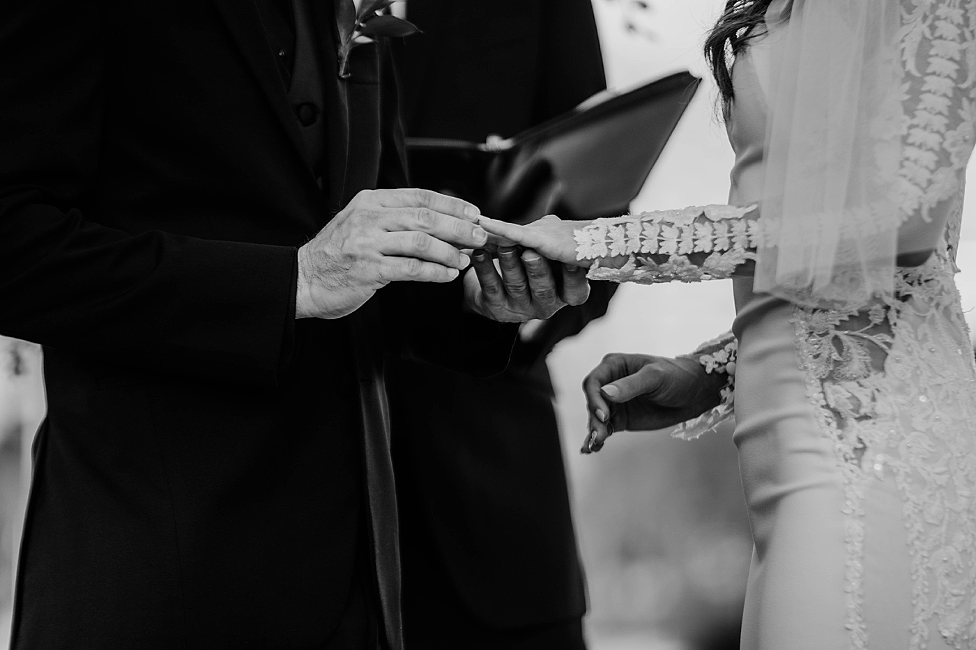 Groom putting wedding band on Bride's finger B&W Waterstone Resort and Marina Wedding captured by South Florida Wedding Photographer Krystal Capone Photography
