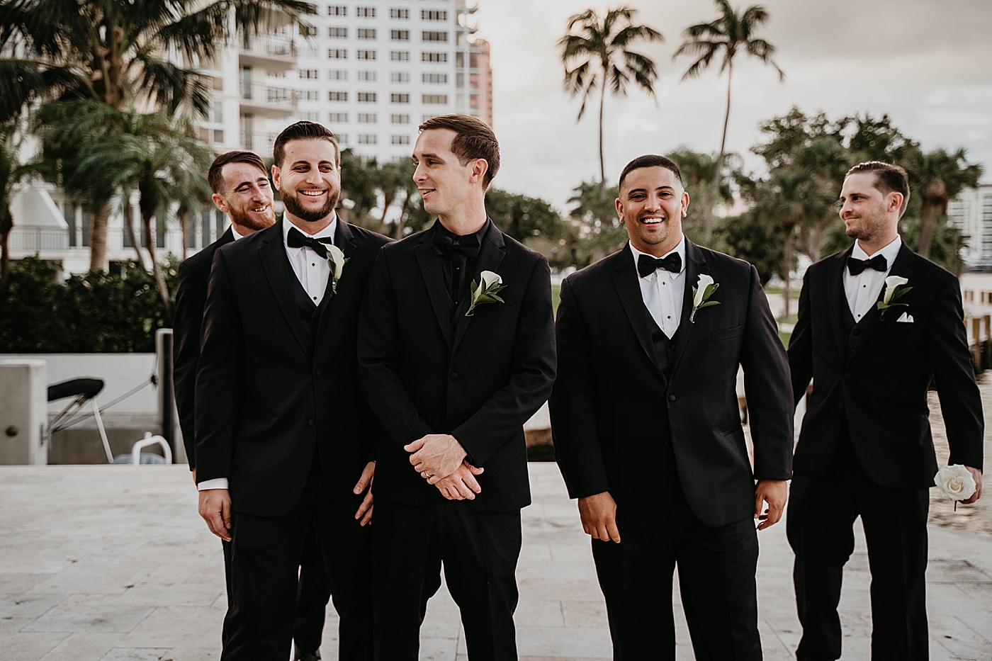 Groom with groomsmen outside with Palm trees Waterstone Resort and Marina Wedding captured by South Florida Wedding Photographer Krystal Capone Photography