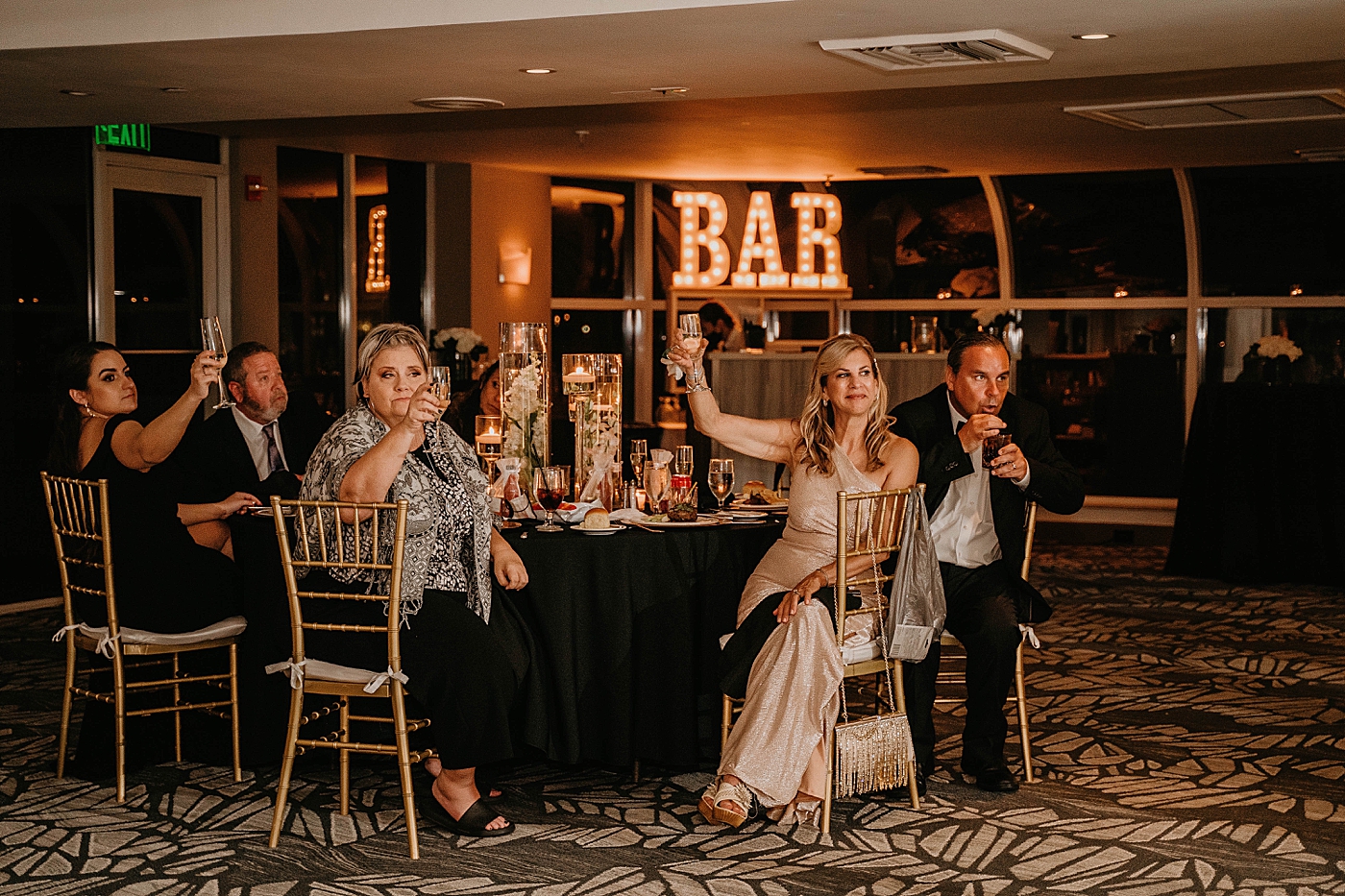 Reception cheers table with Bar in background Waterstone Resort and Marina Wedding captured by South Florida Wedding Photographer Krystal Capone Photography