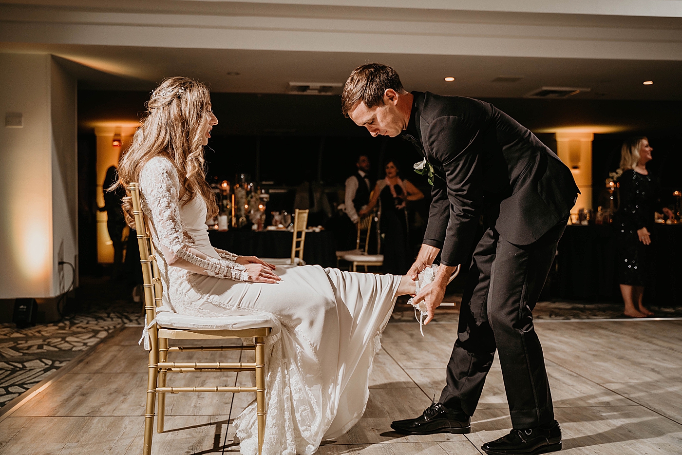 Groom getting the garter Waterstone Resort and Marina Wedding captured by South Florida Wedding Photographer Krystal Capone Photography