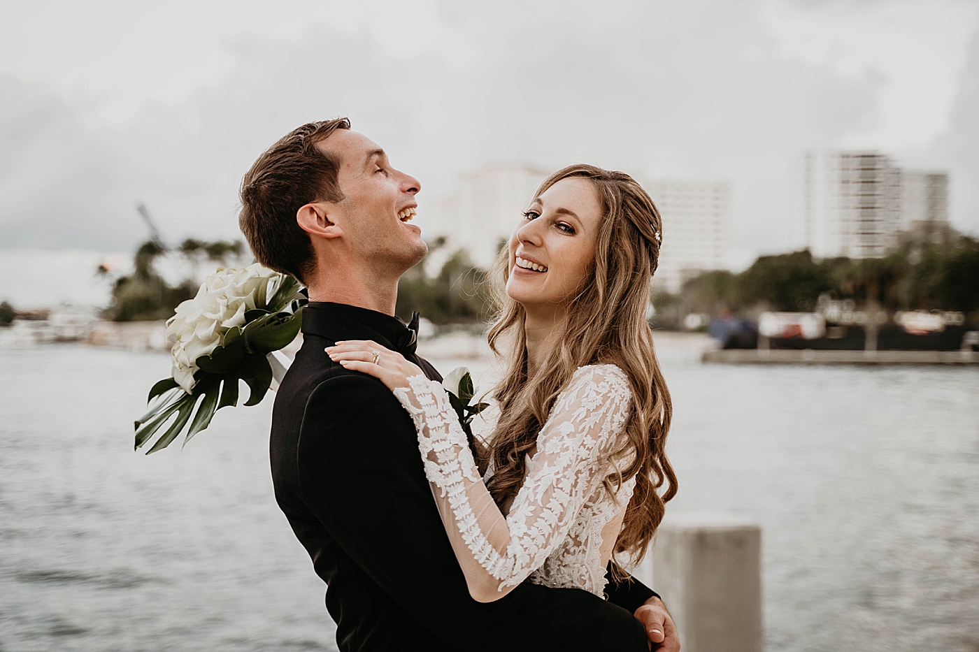 Bride holding each other and laughing Waterstone Resort and Marina Wedding captured by South Florida Wedding Photographer Krystal Capone Photography