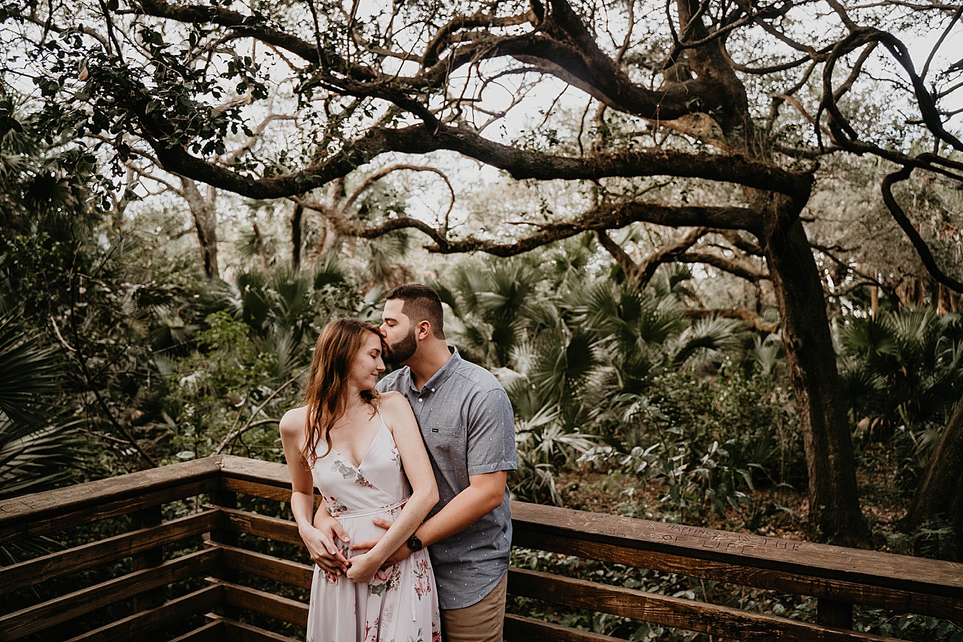 Couple holding each other in front forest Delray Oaks Engagement Photography captured by South Florida Engagement Photographer Krystal Capone Photography