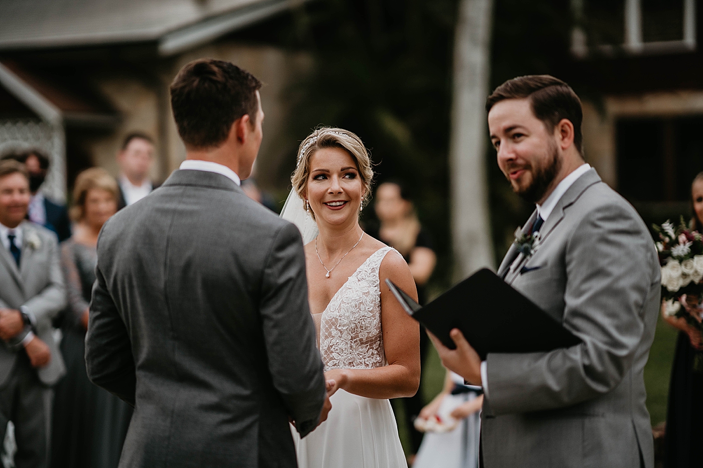 Bride and Groom looking at officiant Homily Ceremony The Estate on the Halifax Wedding Photography captured by South Florida Wedding Photographer Krystal Capone Photography 