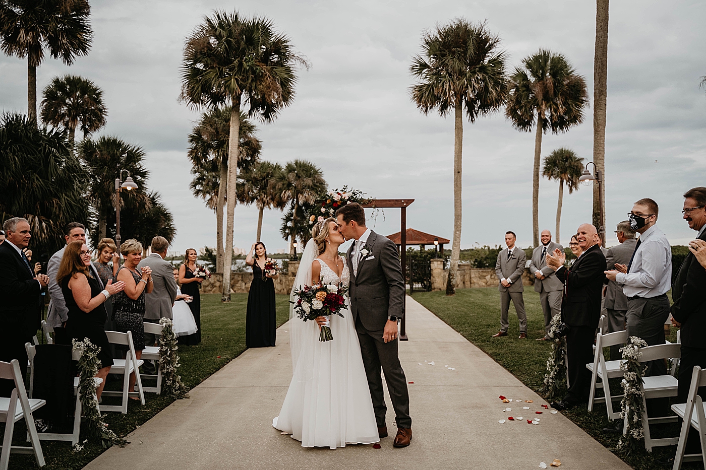 Bride and Groom kissing exiting Ceremony The Estate on the Halifax Wedding Photography captured by South Florida Wedding Photographer Krystal Capone Photography 