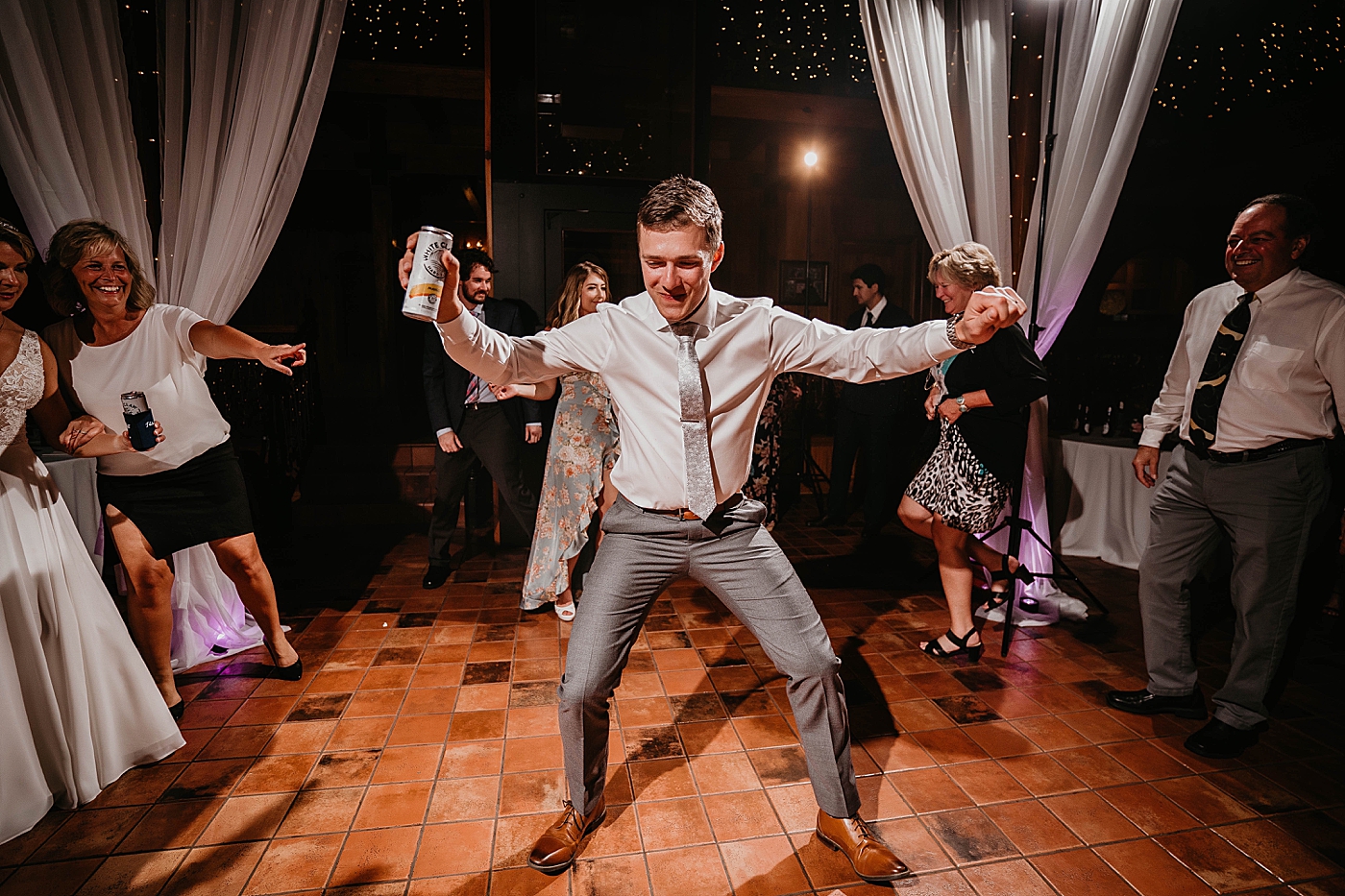 Groom dancing with white claw in hand Reception The Estate on the Halifax Wedding Photography captured by South Florida Wedding Photographer Krystal Capone Photography 