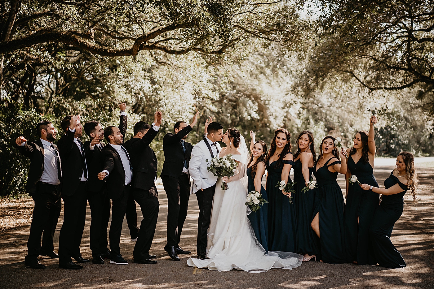 Bride and Groom kissing with Wedding Party cheering them on Lavan Venue Wedding Photography captured by South Florida Wedding Photographer Krystal Capone Photography