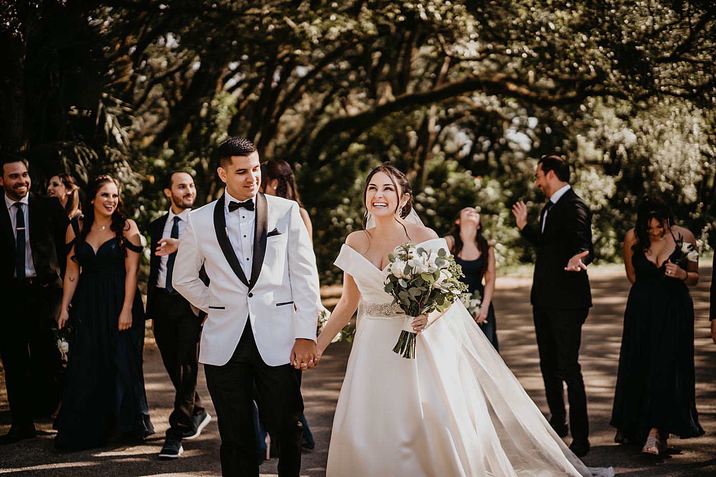 Bride and Groom holding hands with Wedding party behind them Lavan Venue Wedding Photography captured by South Florida Wedding Photographer Krystal Capone Photography