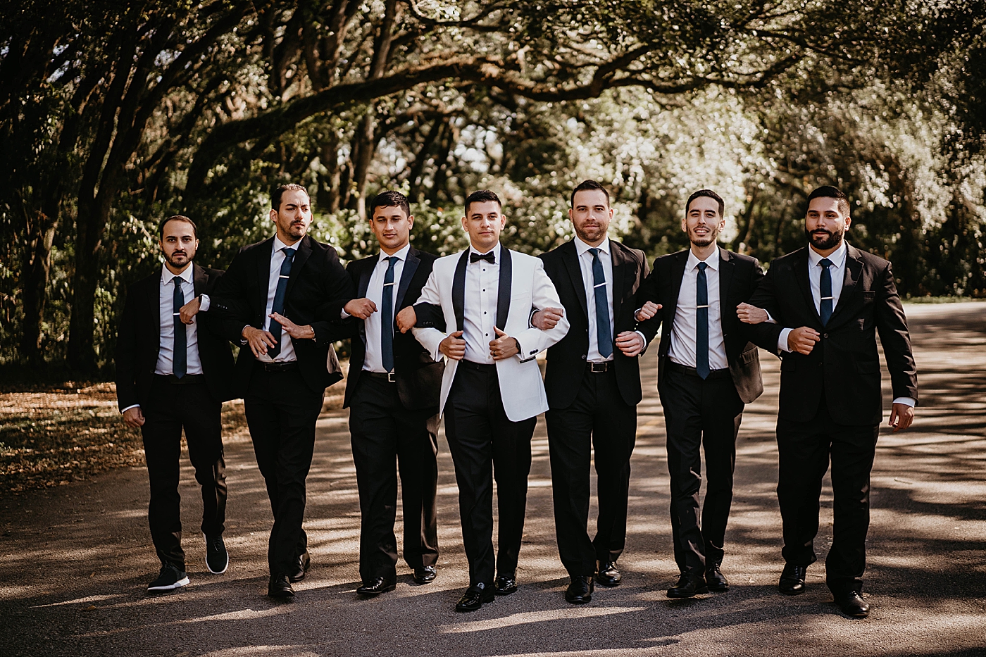 Groom with Groomsmen having their arms intertwined Lavan Venue Wedding Photography captured by South Florida Wedding Photographer Krystal Capone Photography