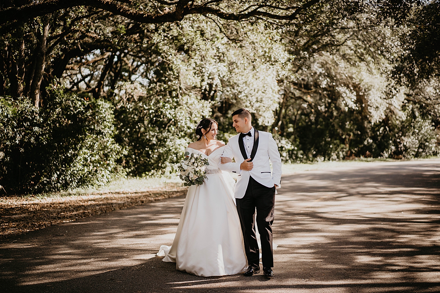 Bride and Groom with intertwined arms walking together Lavan Venue Wedding Photography captured by South Florida Wedding Photographer Krystal Capone Photography