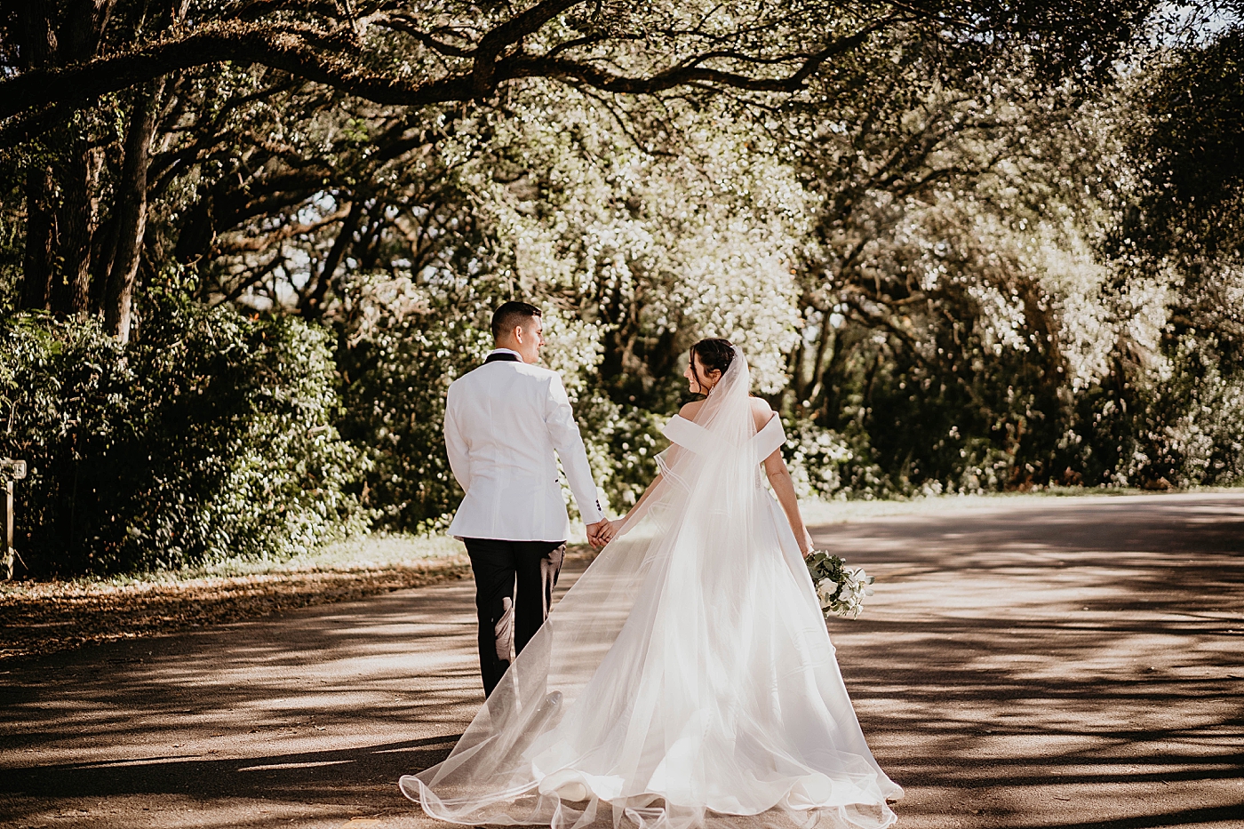 Bride and Groom walking down road and holding hands Lavan Venue Wedding Photography captured by South Florida Wedding Photographer Krystal Capone Photography