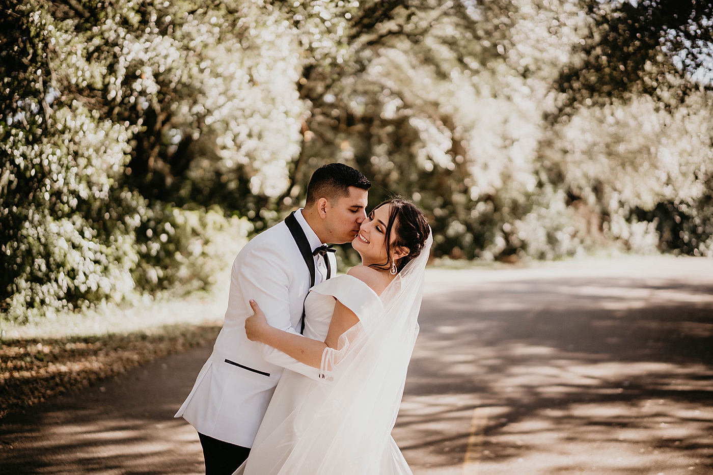 Groom kissing Bride on the road Lavan Venue Wedding Photography captured by South Florida Wedding Photographer Krystal Capone Photography