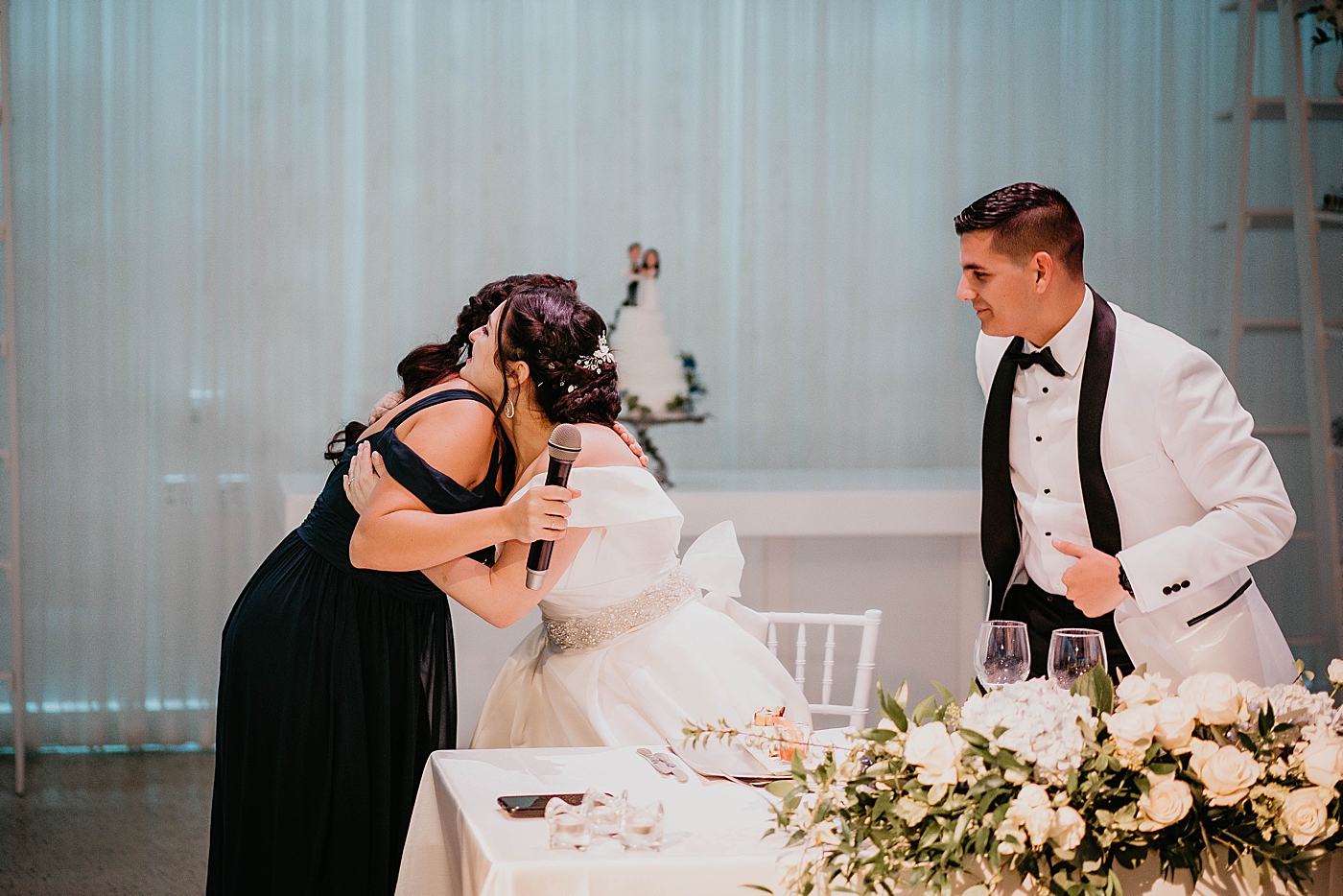 Bride hugging Maid of honor after speech reception Lavan Venue Wedding Photography captured by South Florida Wedding Photographer Krystal Capone Photography