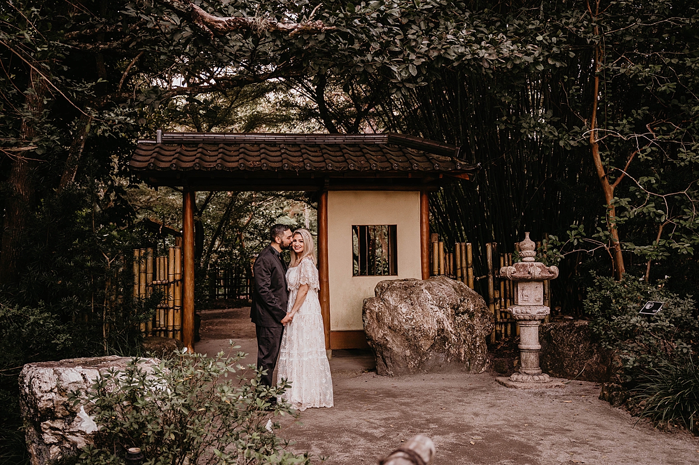 Couple close to each other posing in front of Japanese Garden Scenery Morikami Museum and Japanese Gardens Engagement Photography captured by Krystal Capone Photography