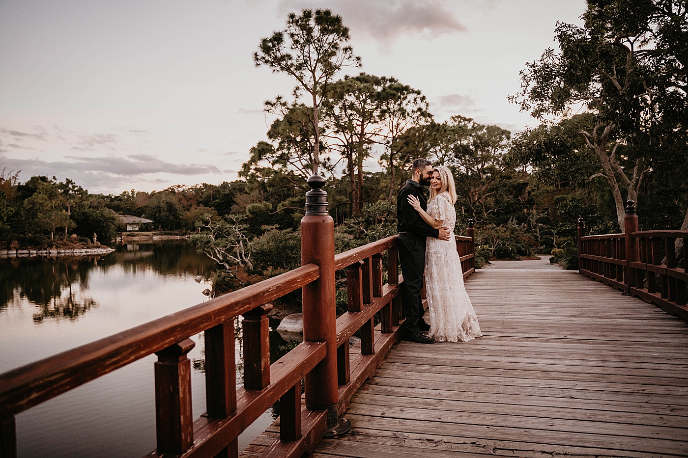 Couple posing on Japanese inspired bridge Morikami Museum and Japanese Gardens Engagement Photography captured by Krystal Capone Photography