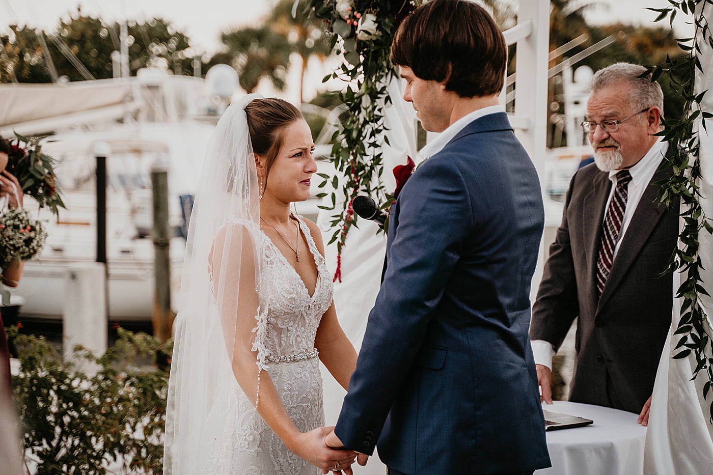 Bride and Groom holding hands by the port Ceremony Out of the Blue Celebrations Wedding Photography captured by South Florida Wedding Photographer Krystal Capone Photography 