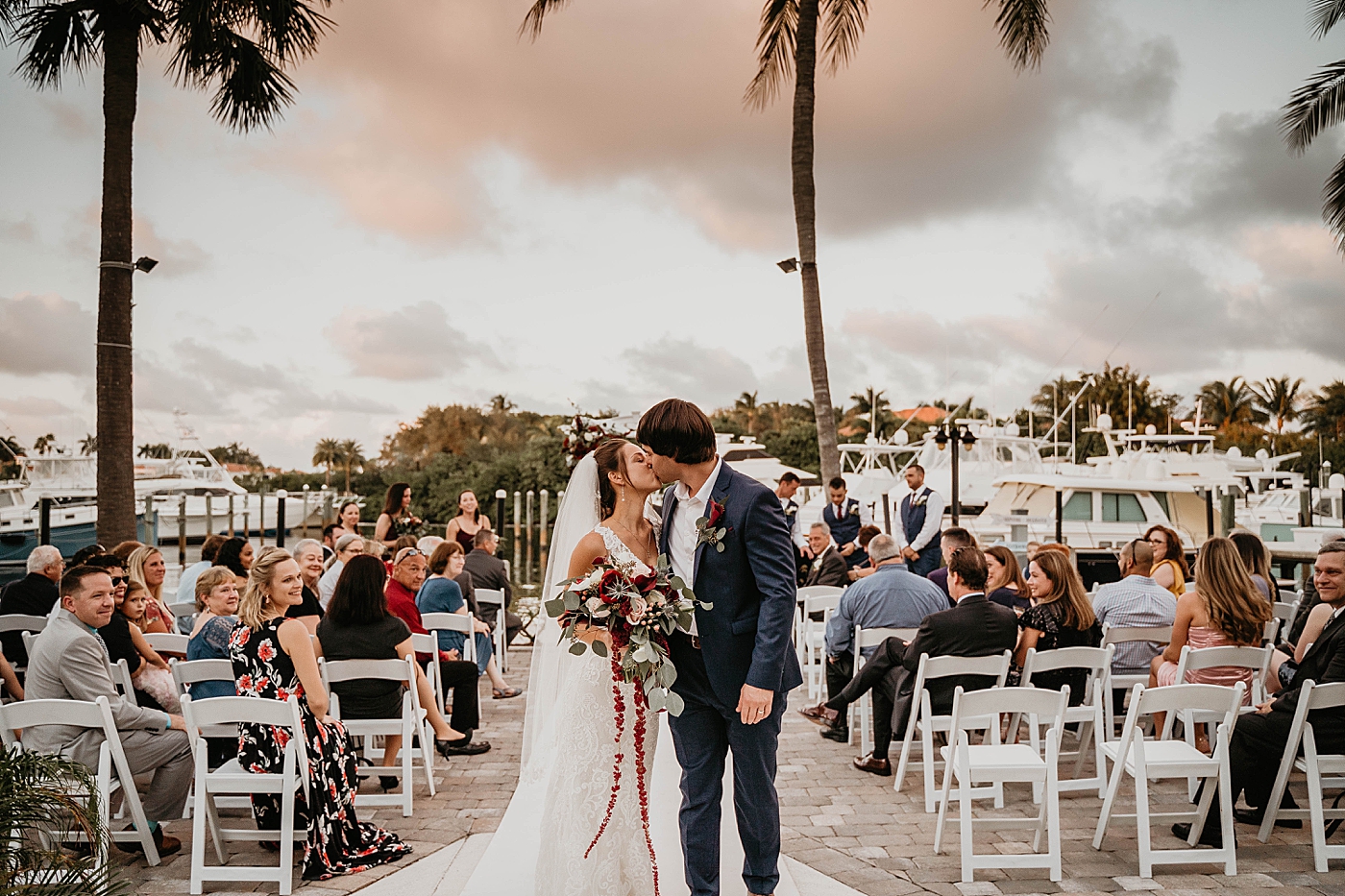 Bride and Groom kissing exiting Ceremony Out of the Blue Celebrations Wedding Photography captured by South Florida Wedding Photographer Krystal Capone Photography 