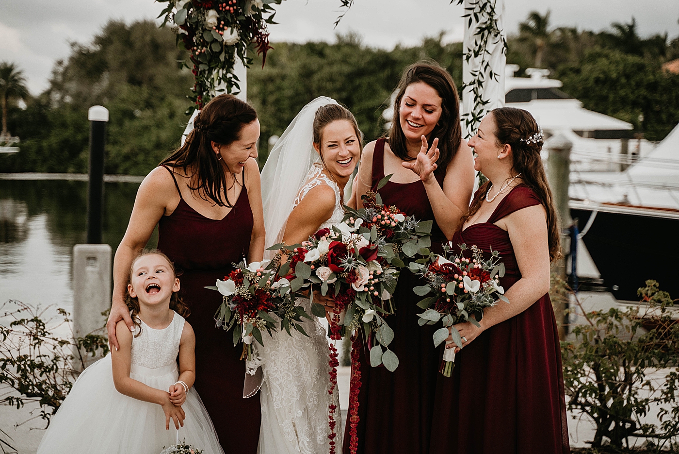 Bride with Bridesmaids and flower girl fun portrait by the water Out of the Blue Celebrations Wedding Photography captured by South Florida Wedding Photographer Krystal Capone Photography 