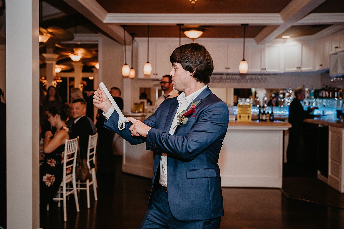 Groom about to toss garter Out of the Blue Celebrations Wedding Photography captured by South Florida Wedding Photographer Krystal Capone Photography 
