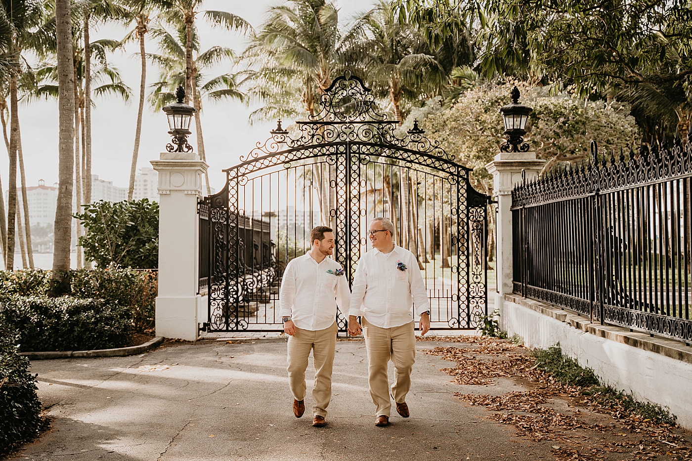 Grooms holding hand in front of gate entrance Palm Beach Elopement Photography captured by South Florida Photographer Krystal Capone Photography 