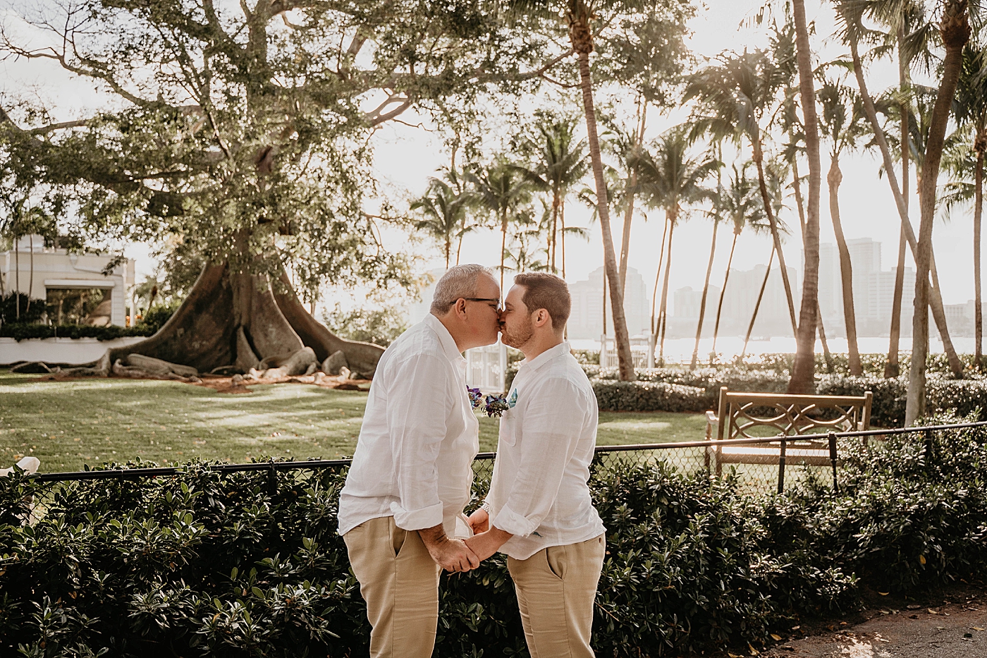Grooms kissing in front of Banyan tree Palm Beach Elopement Photography captured by South Florida Photographer Krystal Capone Photography 