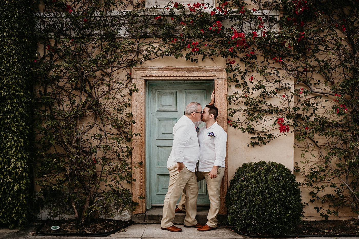Grooms kissing in front of house Palm Beach Elopement Photography captured by South Florida Photographer Krystal Capone Photography 