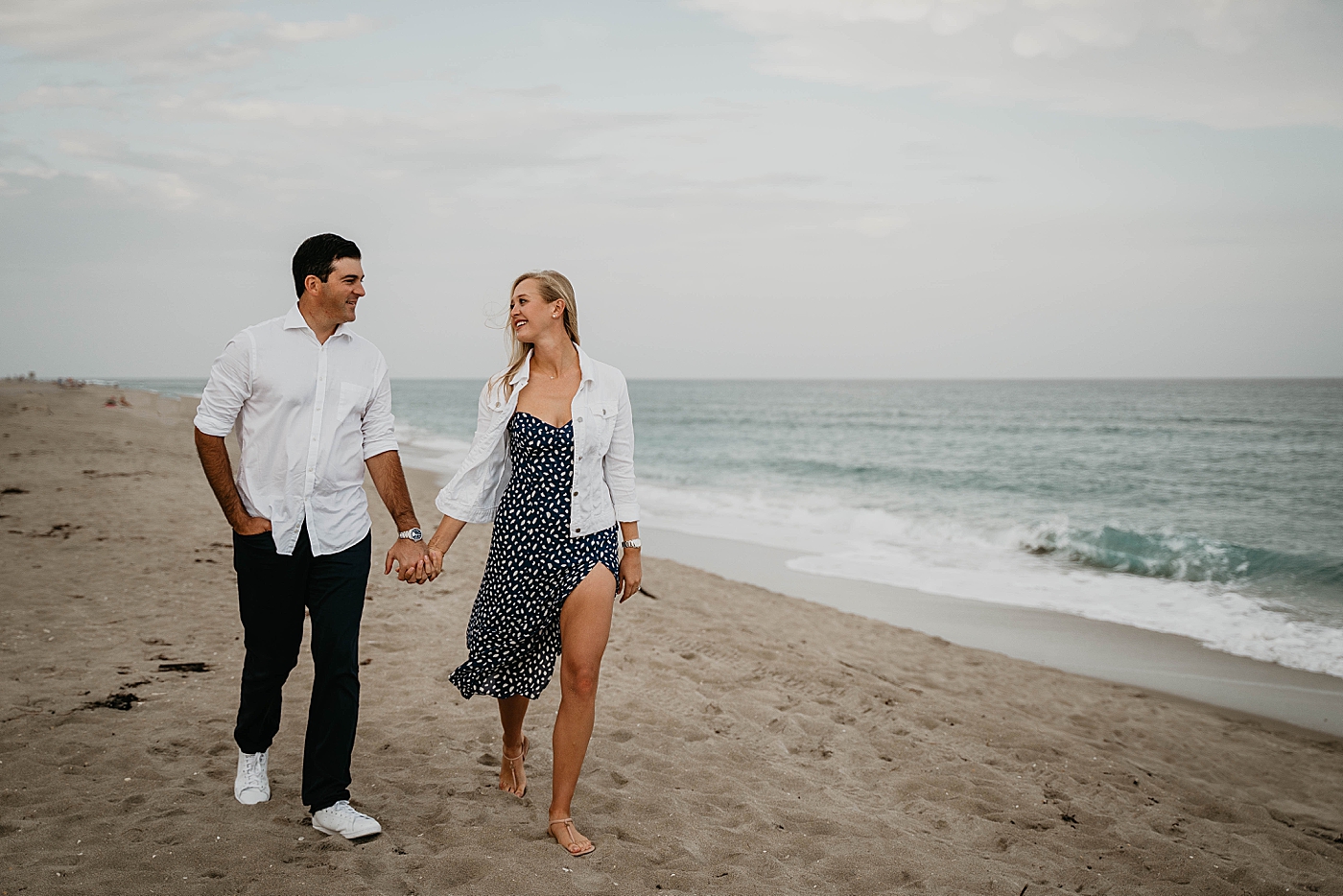 Couple holding hands walking down the beach Palm Beach Engagement Photography captured by South Florida Engagement Photographer Krystal Capone Photography 
