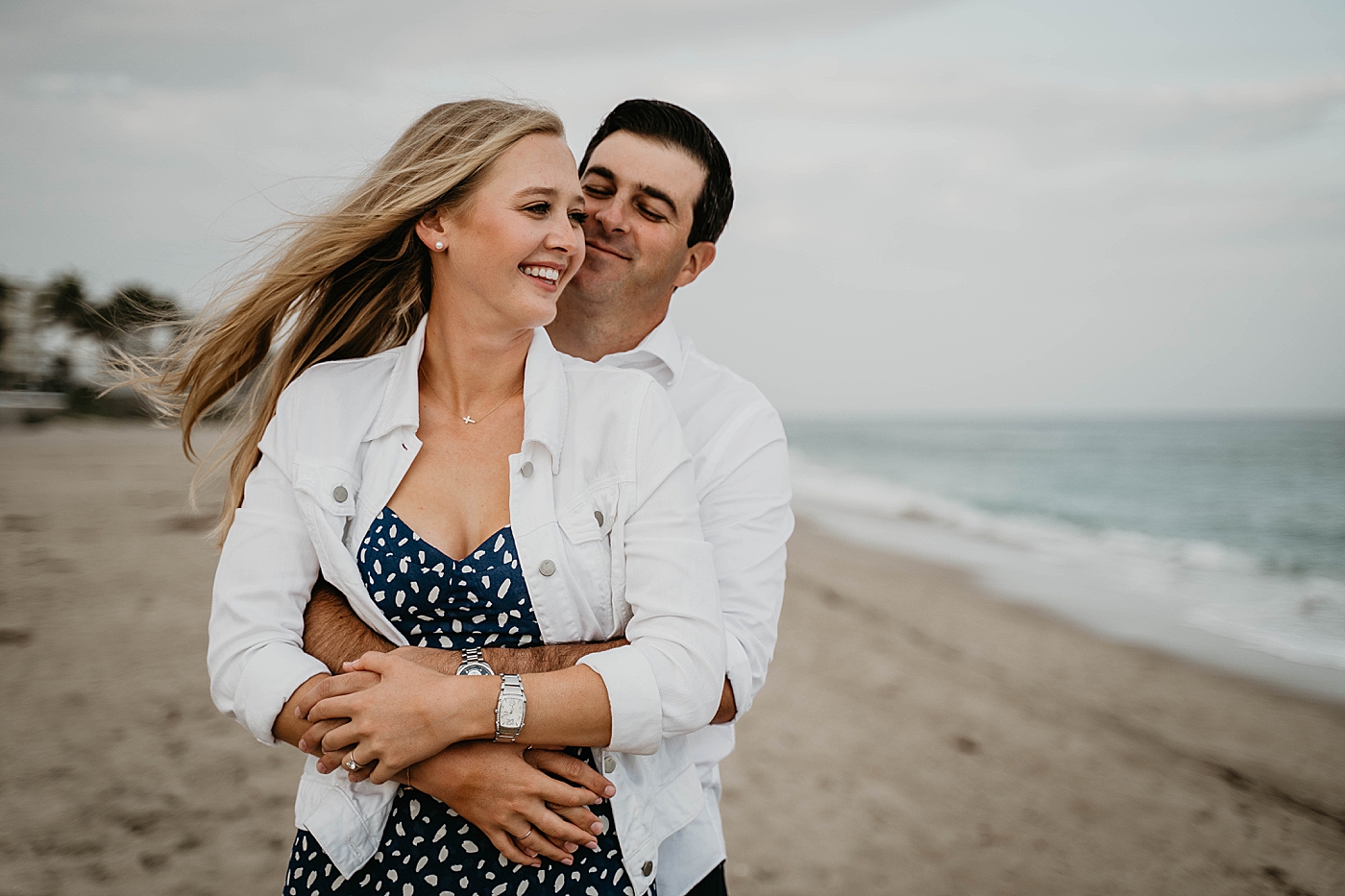 Man holding lady on the beach Palm Beach Engagement Photography captured by South Florida Engagement Photographer Krystal Capone Photography 