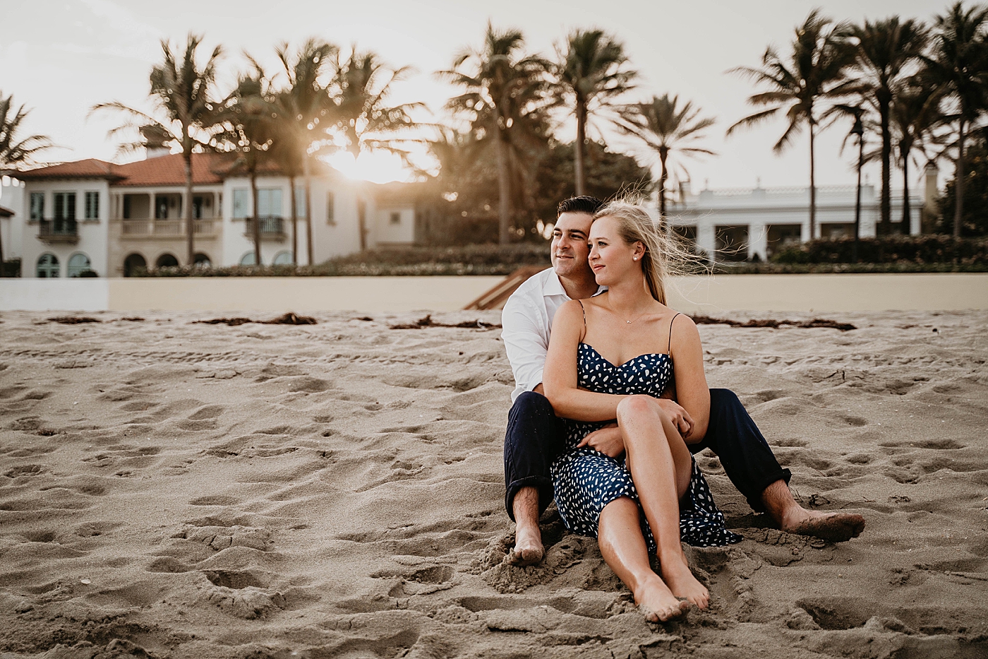 Couple sitting on the beach with a sunset Palm Beach Engagement Photography captured by South Florida Engagement Photographer Krystal Capone Photography 