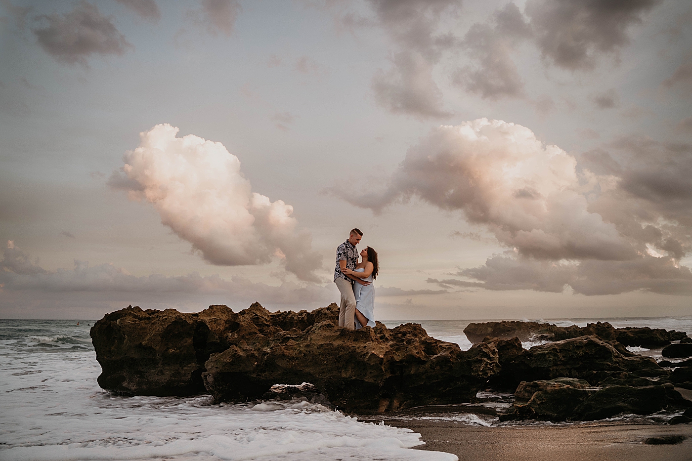Couple on beach rock formation South Florida Beach Photography captured by Krystal Capone Photography