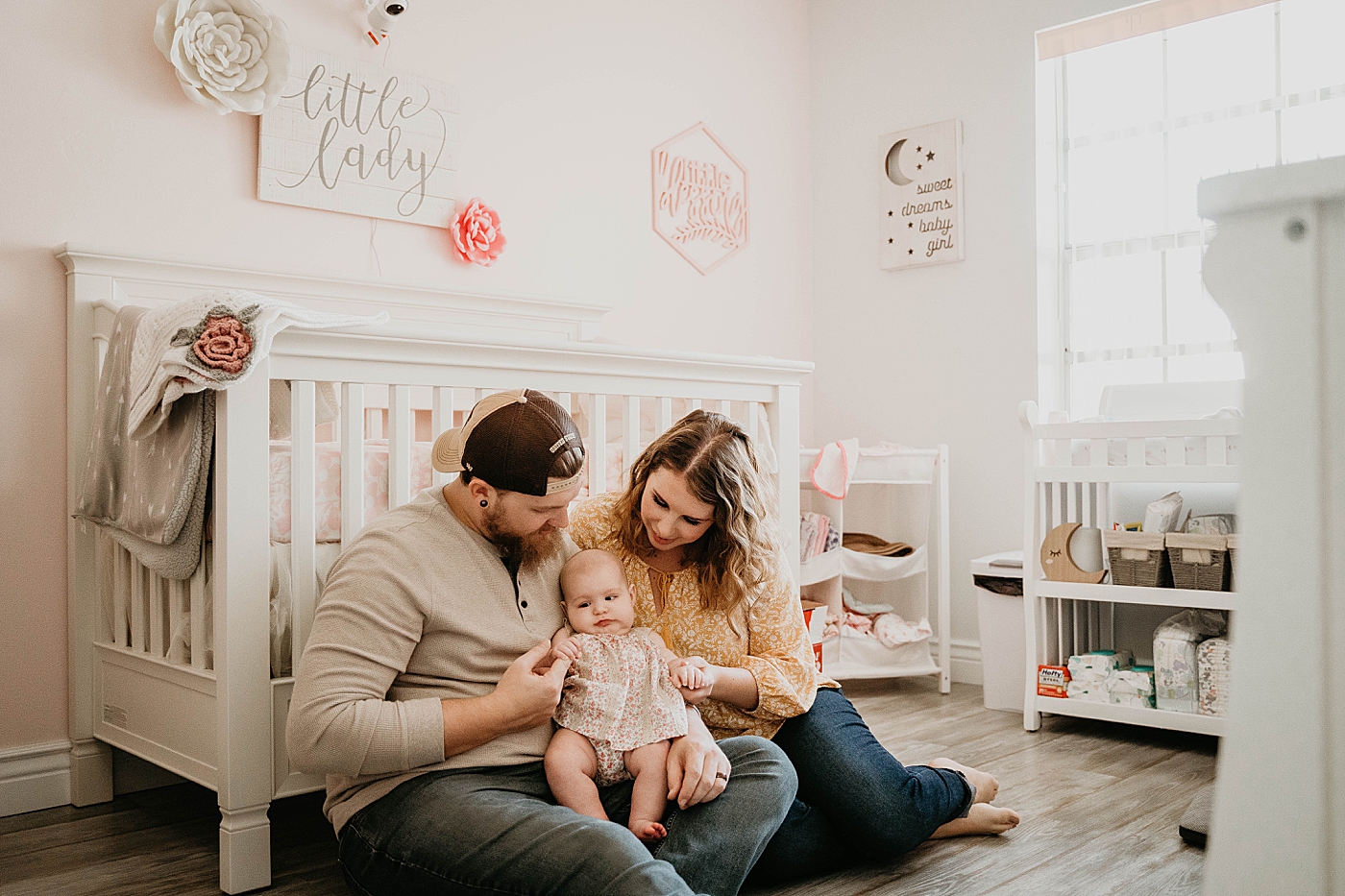 Mom and Dad sitting down with Baby in Little girl's room At Home South Florida Family Photography captured by South Florida Family Photographer Krystal Capone Photography 