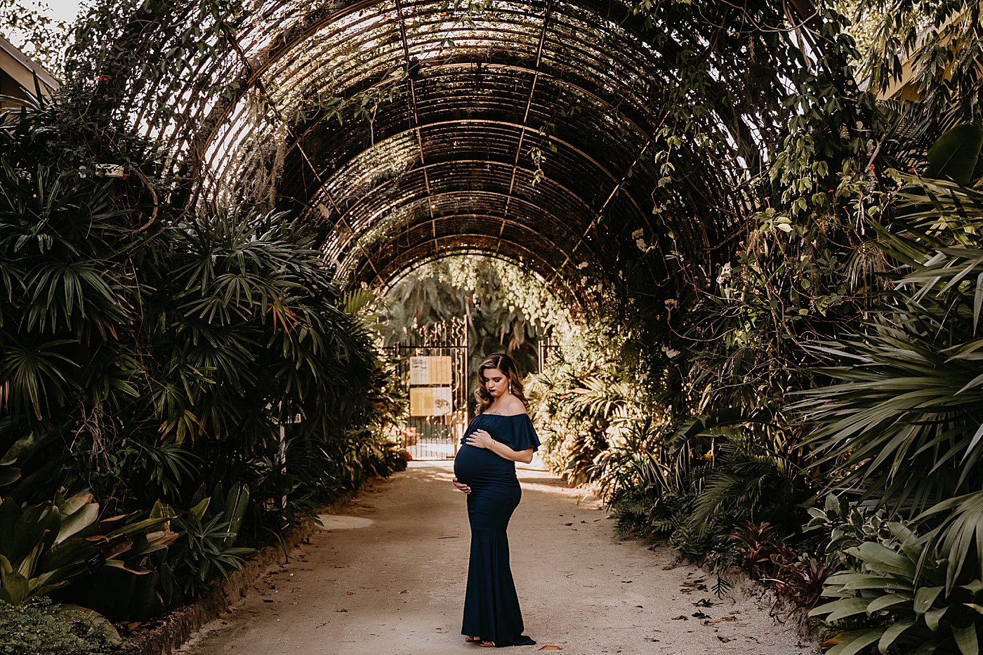 Pregnant mpther under green arch way South Florida Maternity Photography captured by South Florida Family Photographer Krystal Capone Photography 