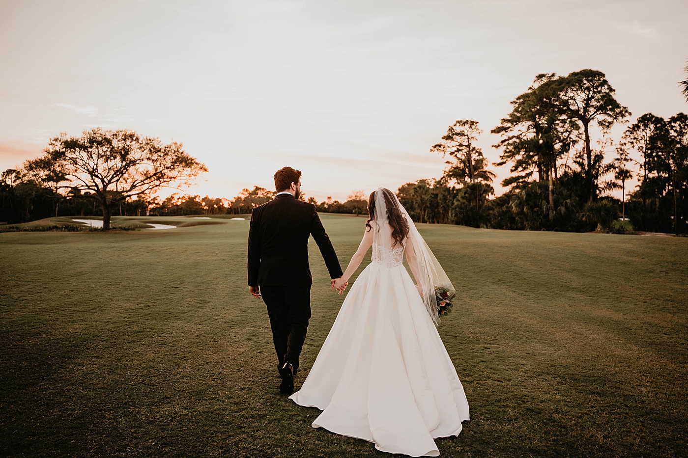 Bride and Groom walking together on the fairway Breakers West Wedding Photography captured by South Florida Wedding Photographer Krystal Capone Photography 