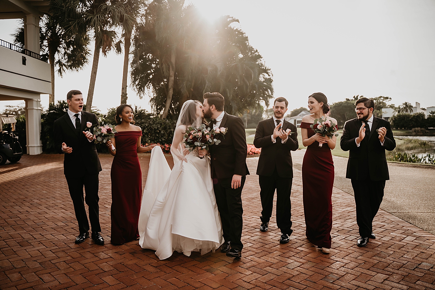 Bride and Groom kissing with Wedding party reaction Breakers West Wedding Photography captured by South Florida Wedding Photographer Krystal Capone Photography 