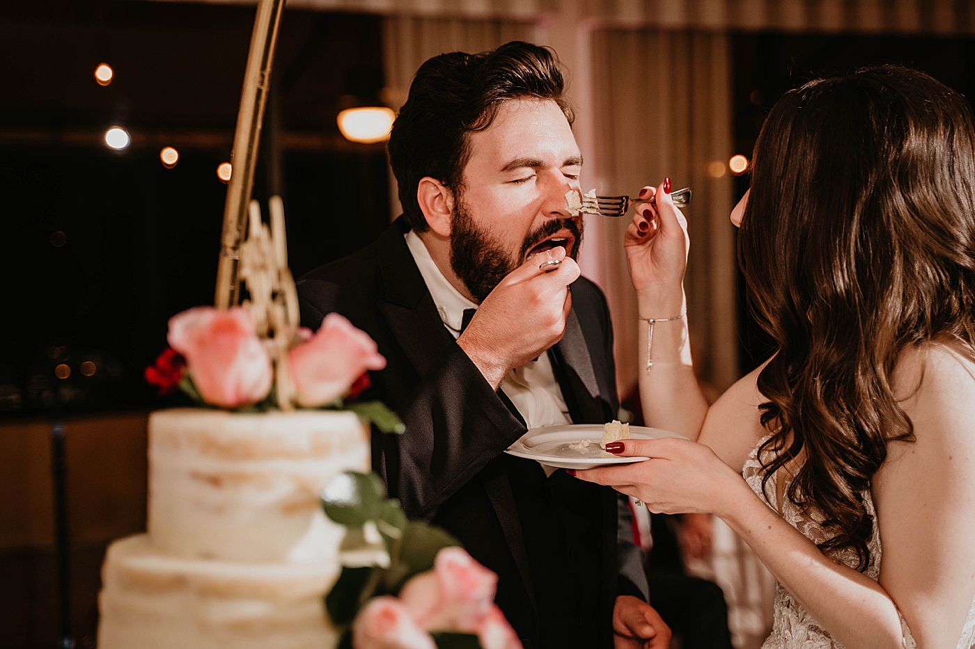 Bride giving messy bite of cake to groom Breakers West Wedding Photography captured by South Florida Wedding Photographer Krystal Capone Photography 