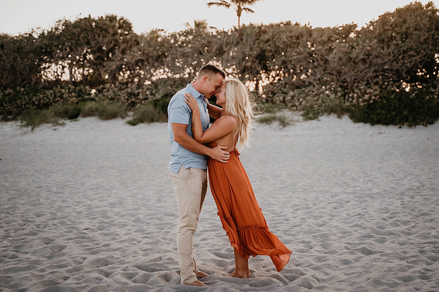 Couple holding each other close on the sand Jupiter Beach Engagement Photography captured by South Florida Engagement Photographer Krystal Capone Photography 