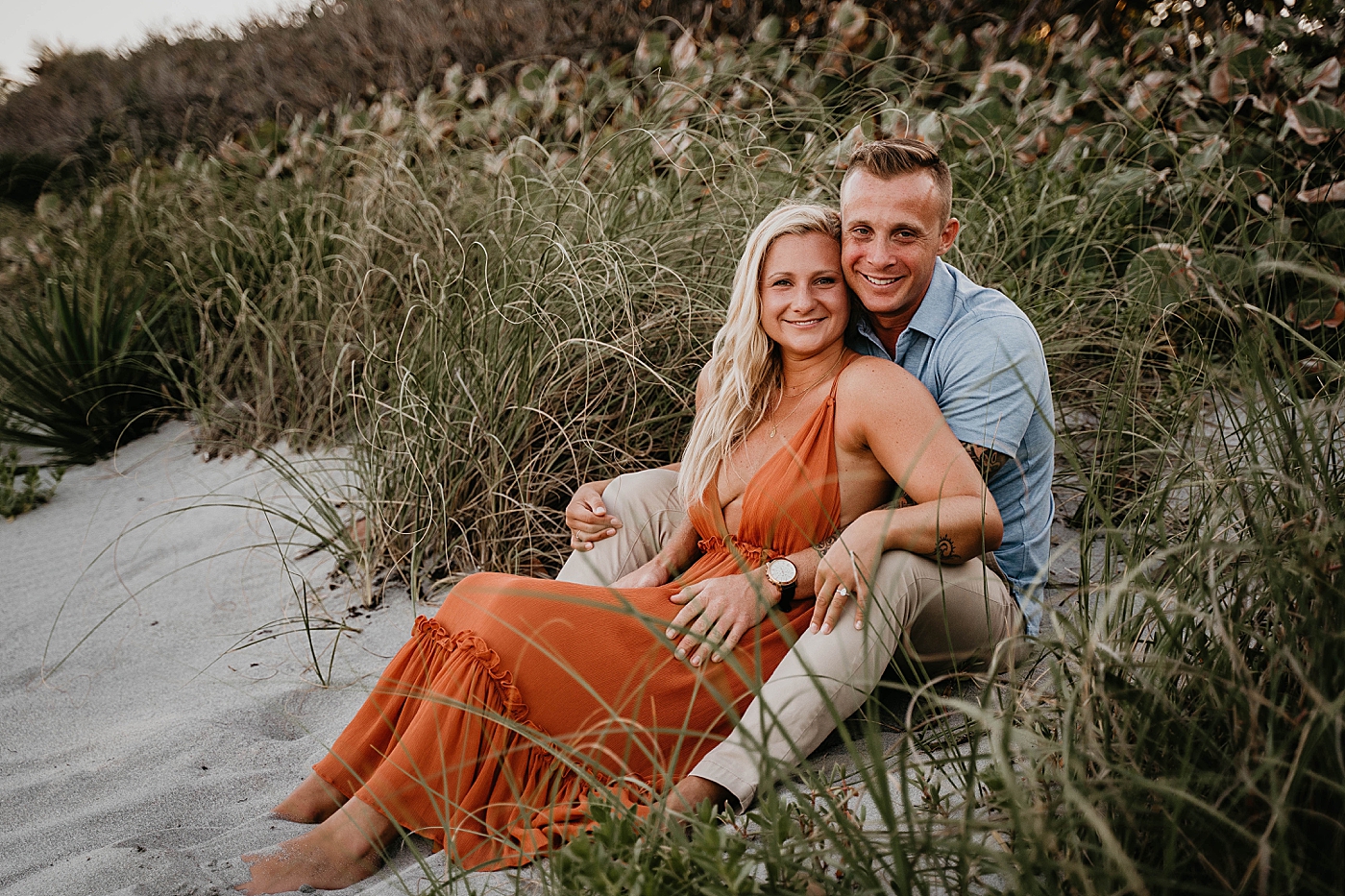 Couple sitting on the sand and holding each other Jupiter Beach Engagement Photography captured by South Florida Engagement Photographer Krystal Capone Photography 
