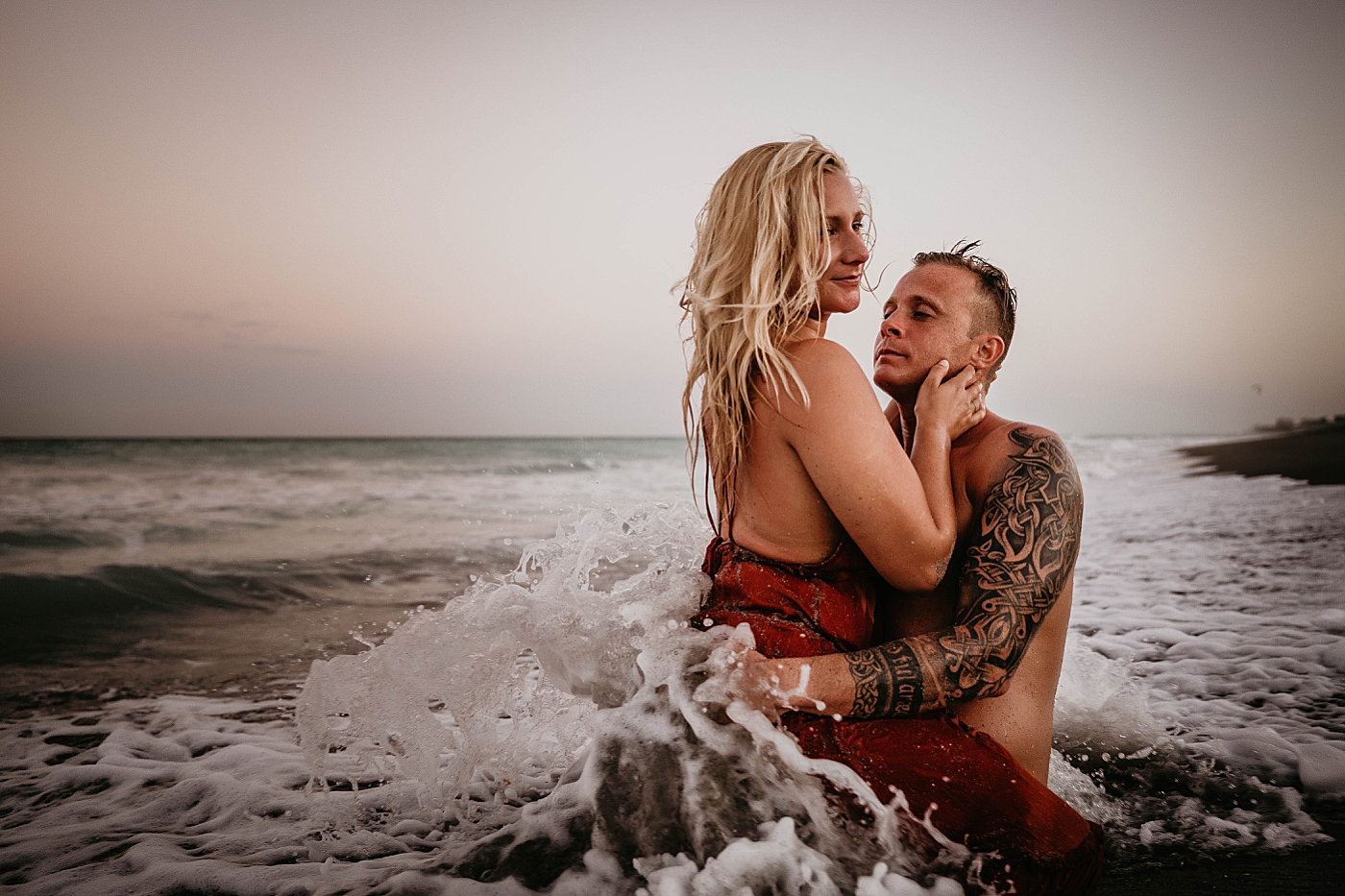 Couple holding each other in the ocean water Jupiter Beach Engagement Photography captured by South Florida Engagement Photographer Krystal Capone Photography 