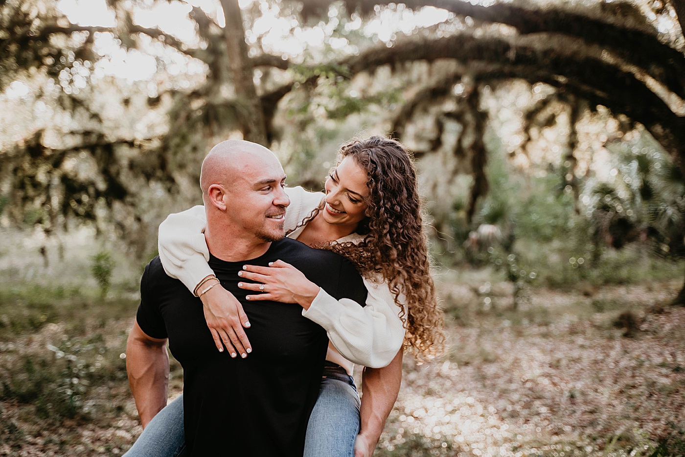 Couple piggy backing Romantic Riverbend Park Engagement Photography captured by South Florida Photographer Krystal Capone Photography