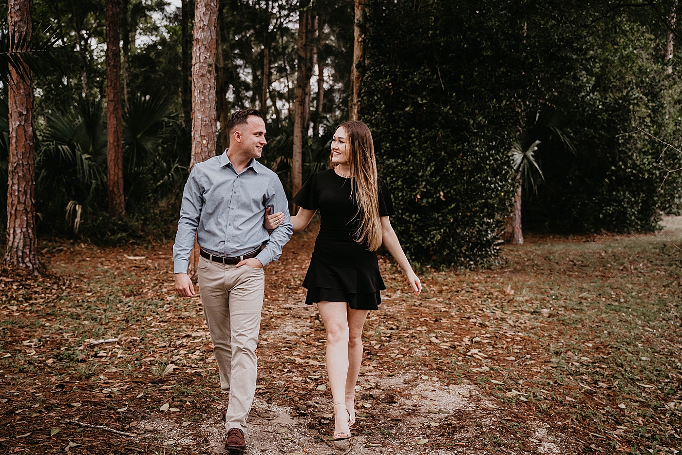 Couple arm in arm walking together in the forest Rustic South Florida Engagement Photography captured by South Florida Engagement Photographer Krystal Capone Photography 