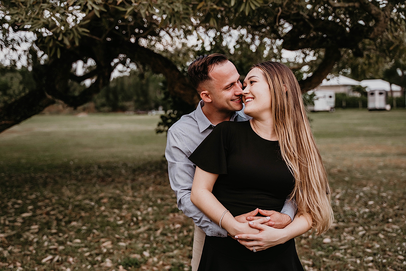Man holding lady on fall grass field about to kiss Rustic South Florida Engagement Photography captured by South Florida Engagement Photographer Krystal Capone Photography 
