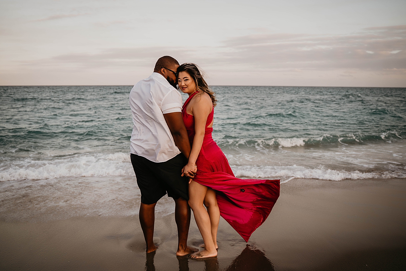 Couple holding hands in front of the ocean as waves come in Palm Beach Anniversary Photography captured by South Florida Family Photographer Krystal Capone Photography
