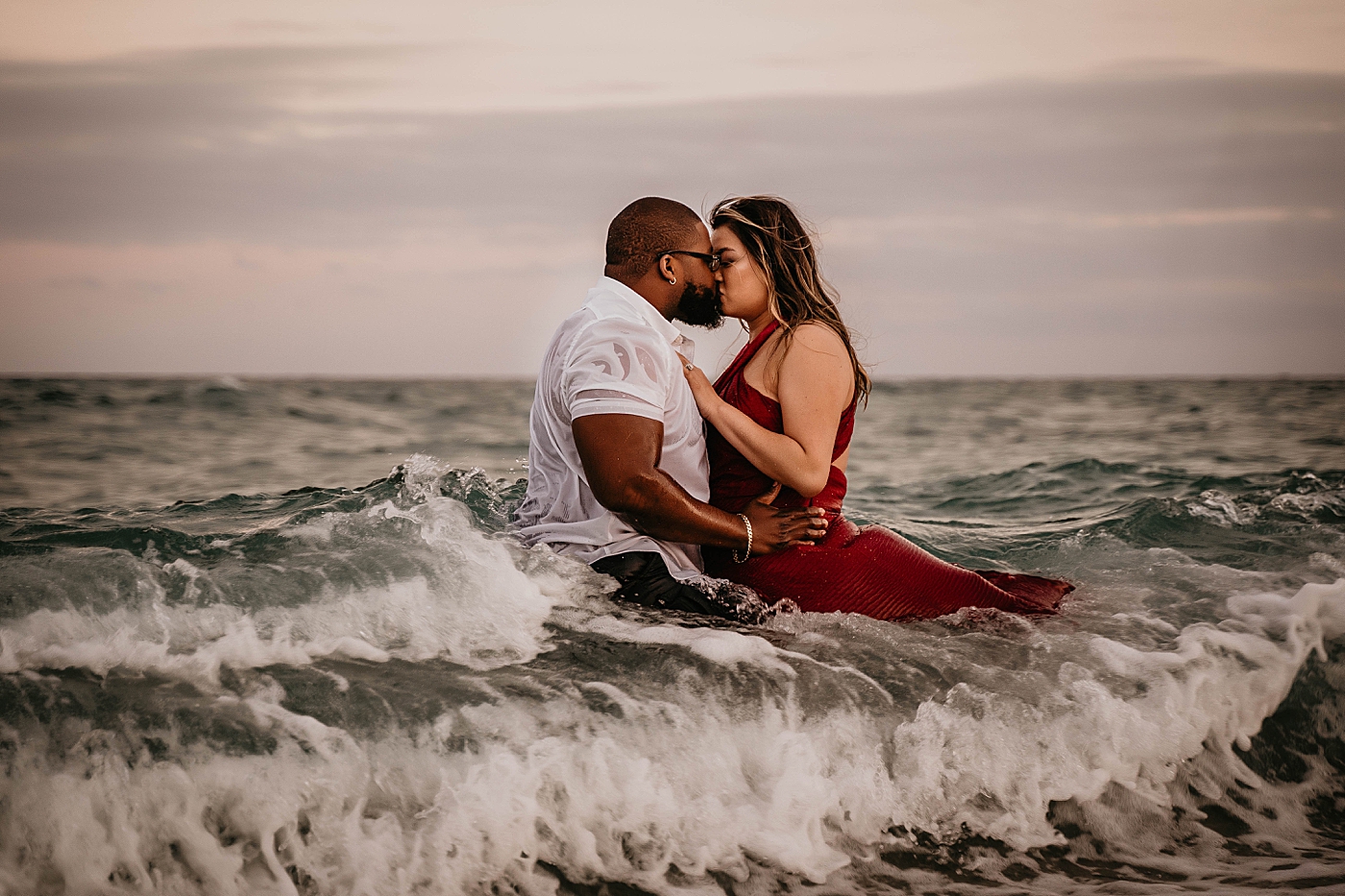Couple standing in the ocean kissing Palm Beach Anniversary Photography captured by South Florida Family Photographer Krystal Capone Photography