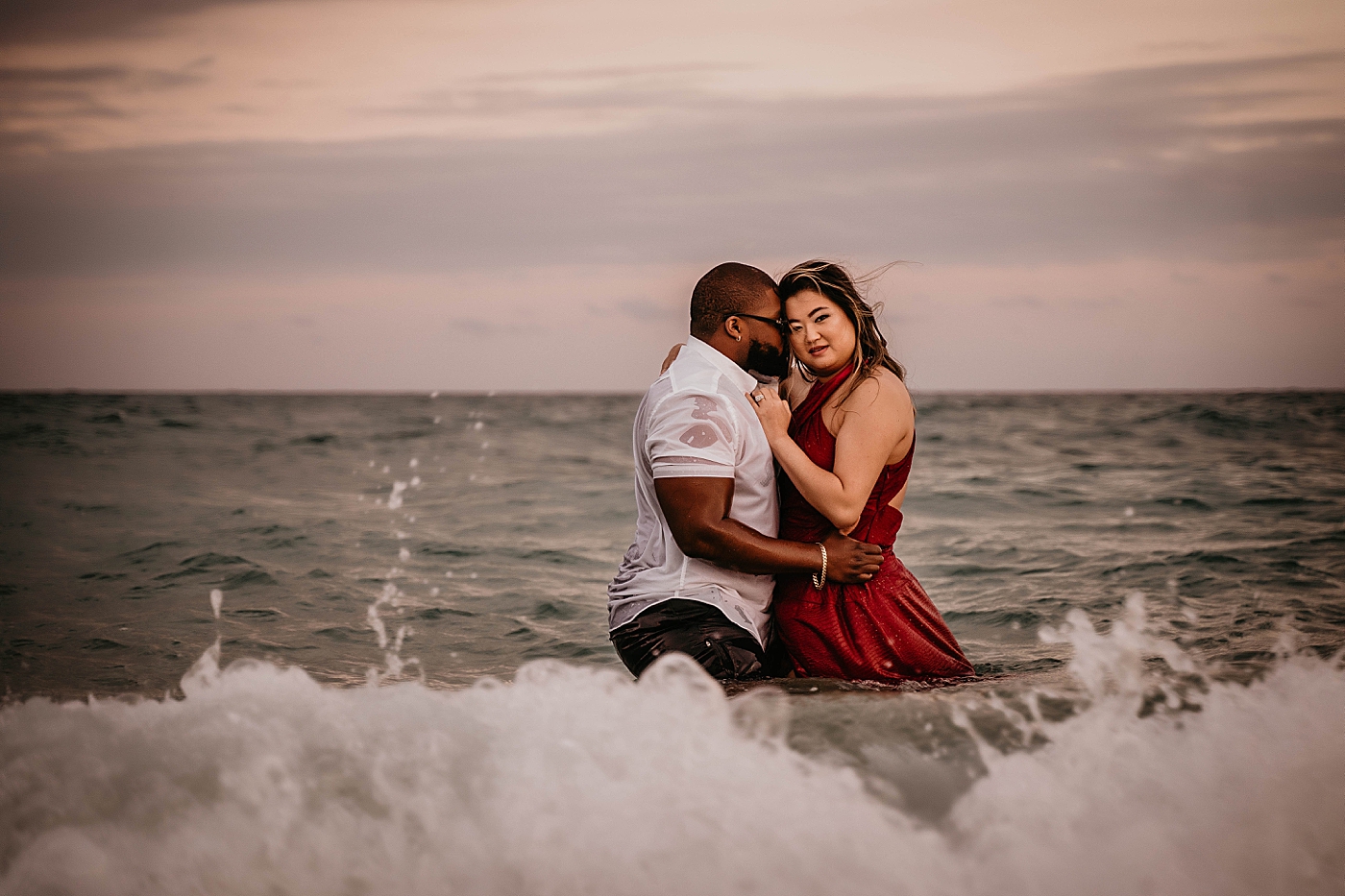 Husband kissing wife while in the ocean water Palm Beach Anniversary Photography captured by South Florida Family Photographer Krystal Capone Photography
