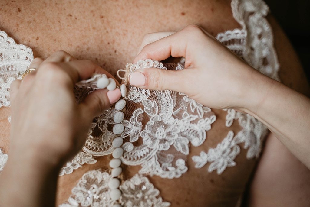 Closeup of Bride buttoning up wedding dress 94th Aero Squadron Miami Wedding Photography captured by South Florida Engagement Photographer Krystal Capone Photography 