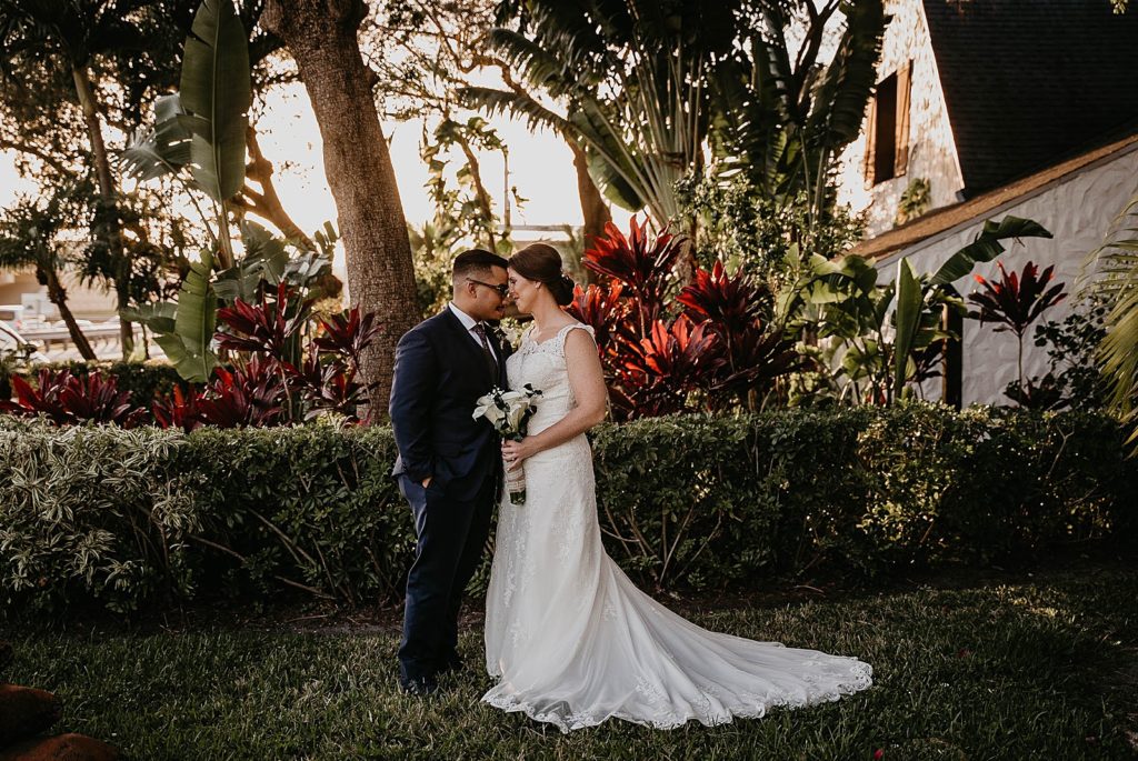 Bride and Groom nuzzling in grass field 94th Aero Squadron Miami Wedding Photography captured by South Florida Engagement Photographer Krystal Capone Photography 