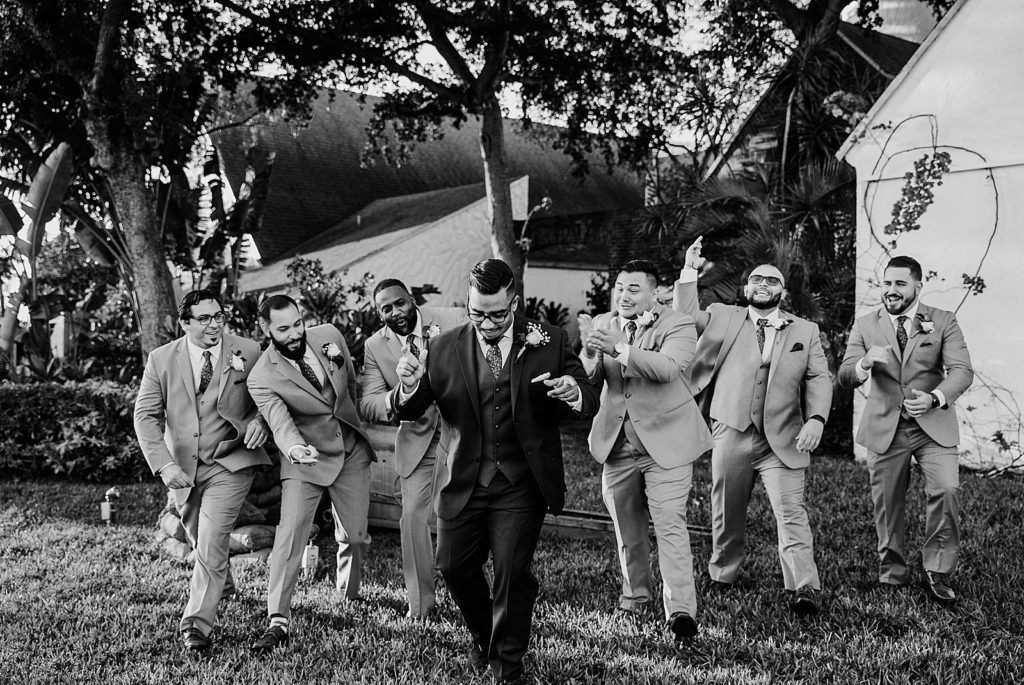 B&W of happy groom snapping with groomsmen celebrating 94th Aero Squadron Miami Wedding Photography captured by South Florida Engagement Photographer Krystal Capone Photography 