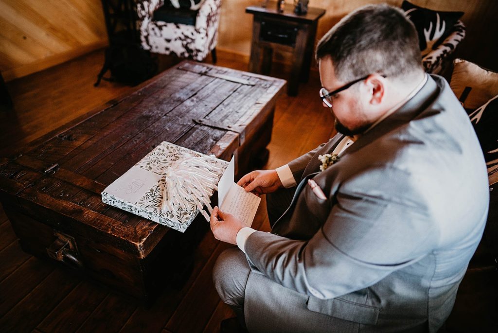 Groom reading letter from Bride with gift after getting ready Ever After Farms Wedding Photography captured by South Florida Wedding Photographer Krystal Capone Photography 